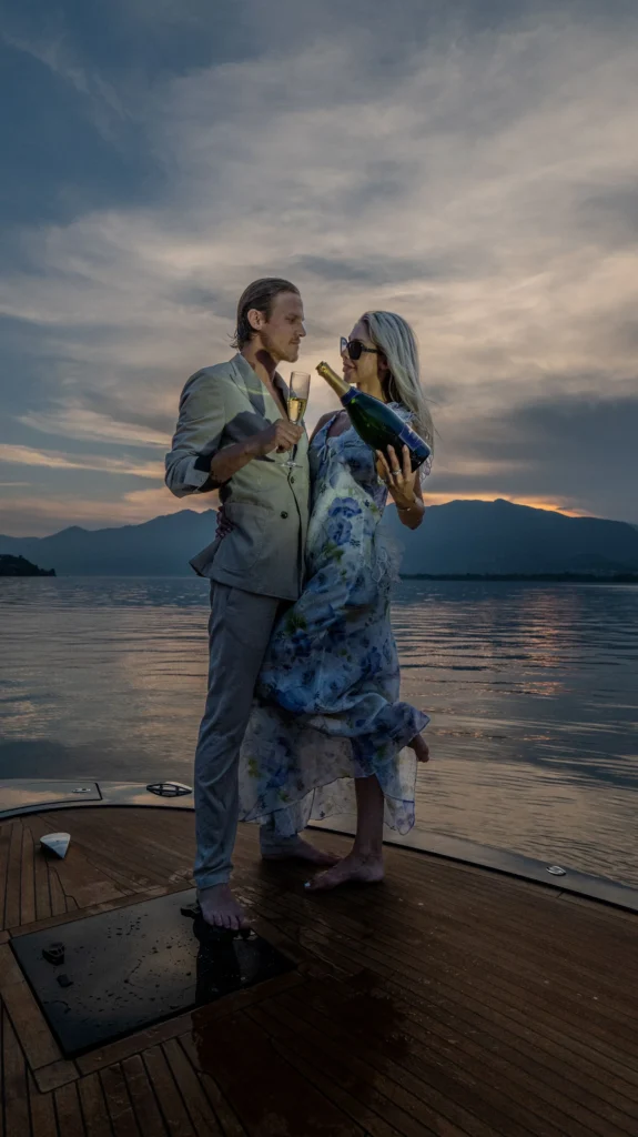 Couple sharing champagne on a yacht deck at sunset