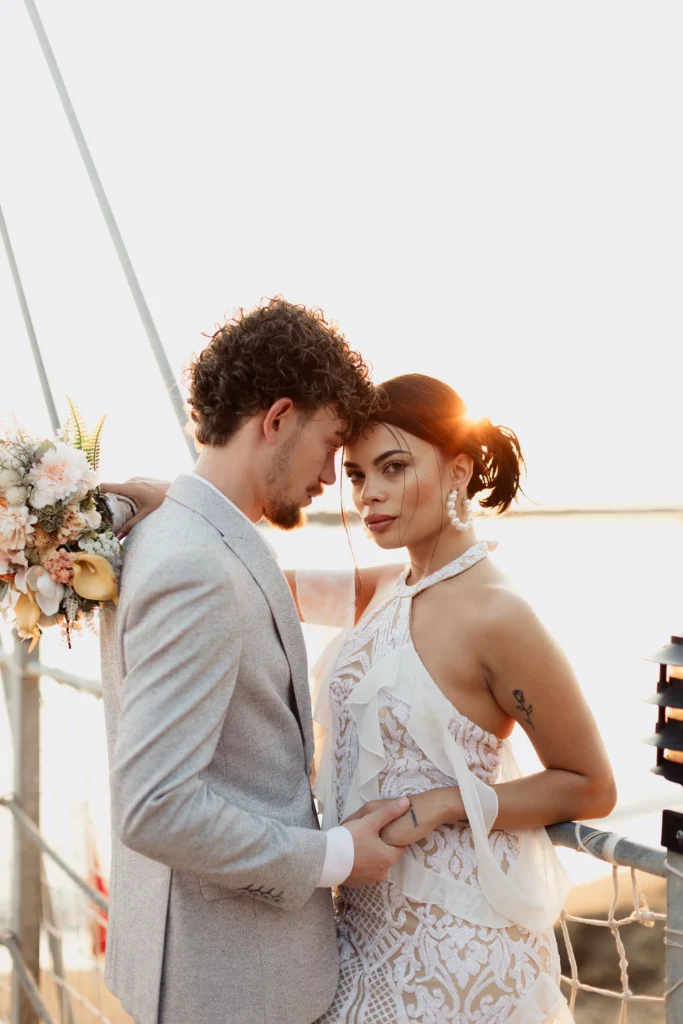 Couple celebrating a wedding aboard a yacht with the sea behind them