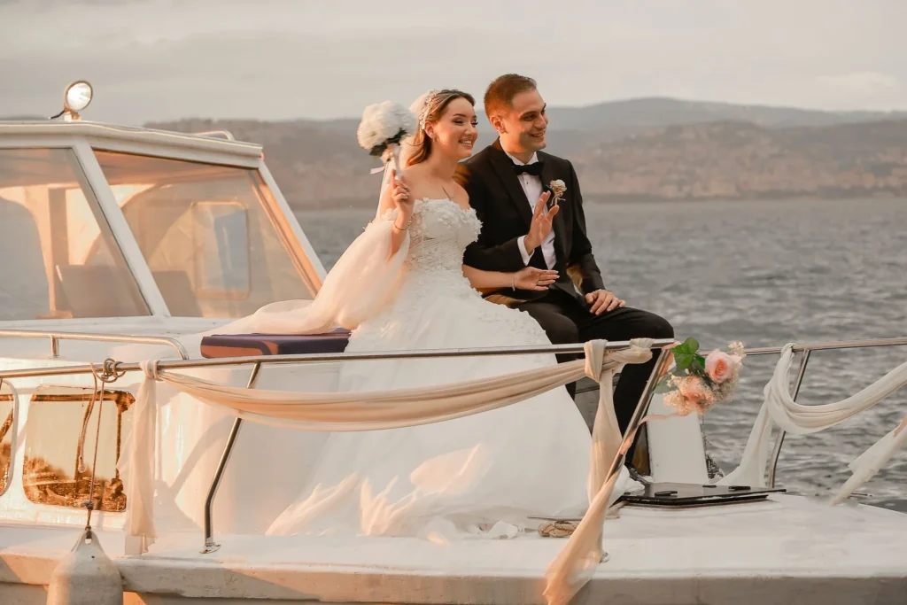 Bride and groom seated on a decorated boat at sea